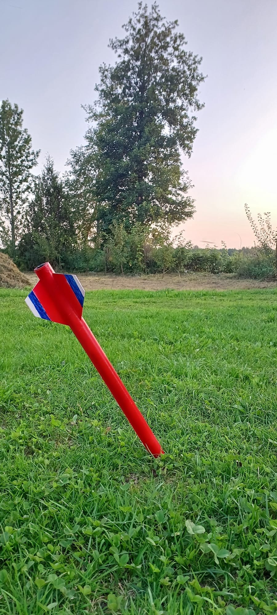 Red dummy rocket standing in a field